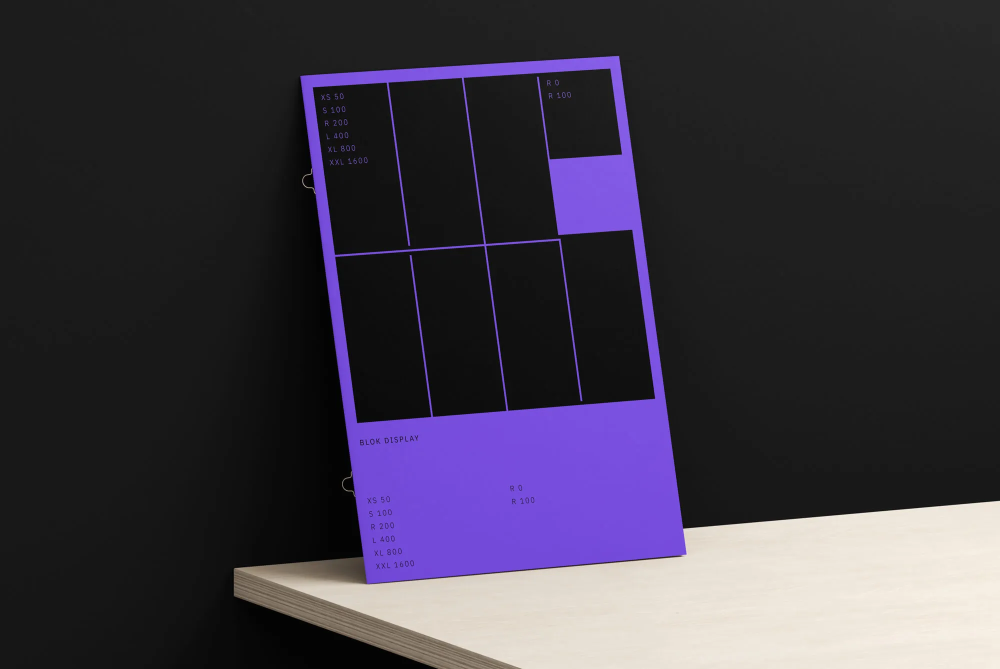 Blok Display specimen poster in purple and black, leaning on a wooden shelf